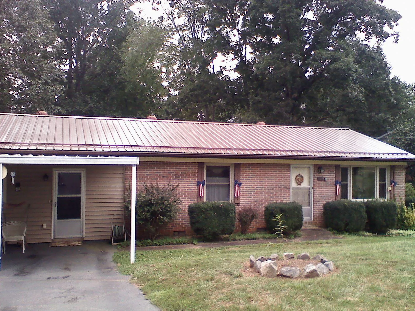 Bronze metal roof and carport on a brick ranch home — Roof Repair work by our crew in Melrose